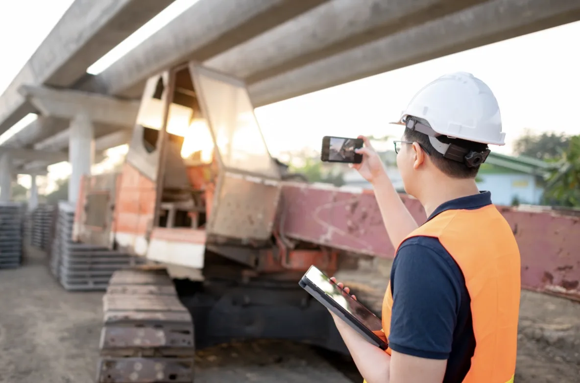 Tecnico in cantiere che scatta una foto con il cellulare
